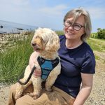 portrait of Joanna Woodward sitting at a state park with her dog