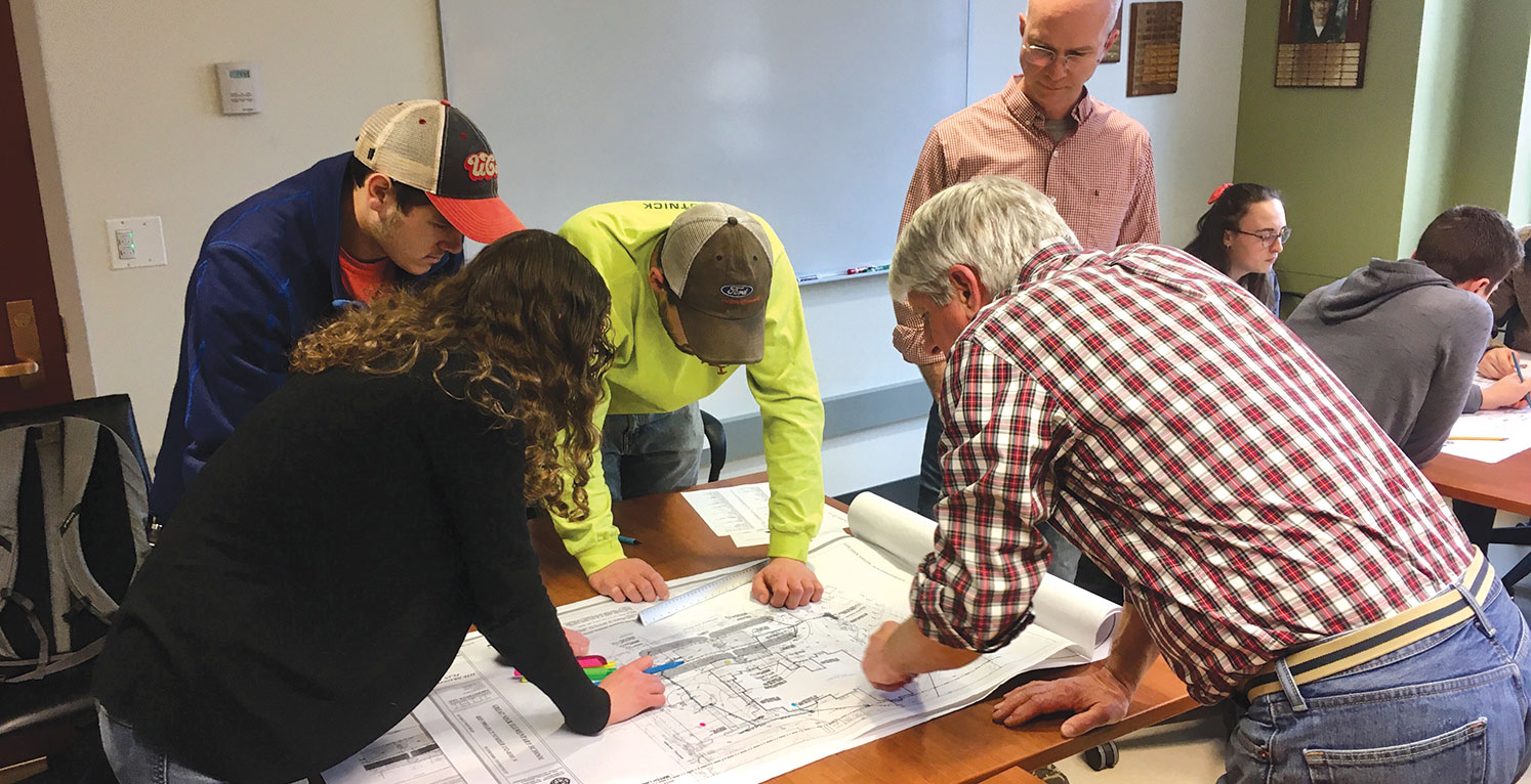 Land Use Academy map reading class students reviewing a map.