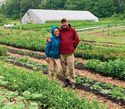 Putnam farm owners who participate in Extension programs pose near their greenhouse.