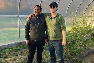 two men post in a Mashantucket greenhouse