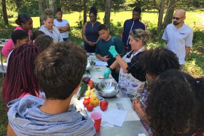 Extension educator showing a group how to cook.