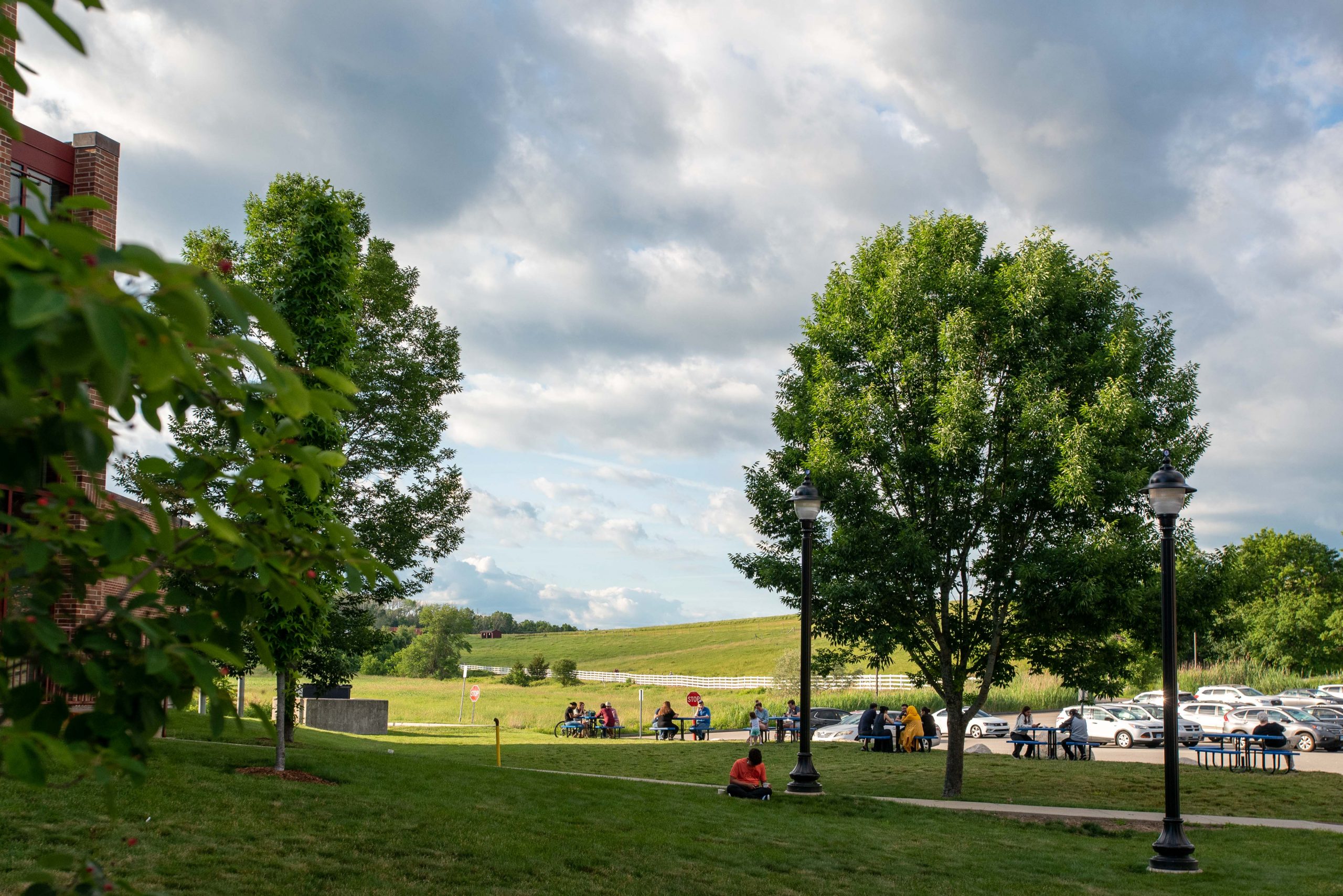 People sitting outside of the UConn Dairy Bar with Horse Barn Hill in the background